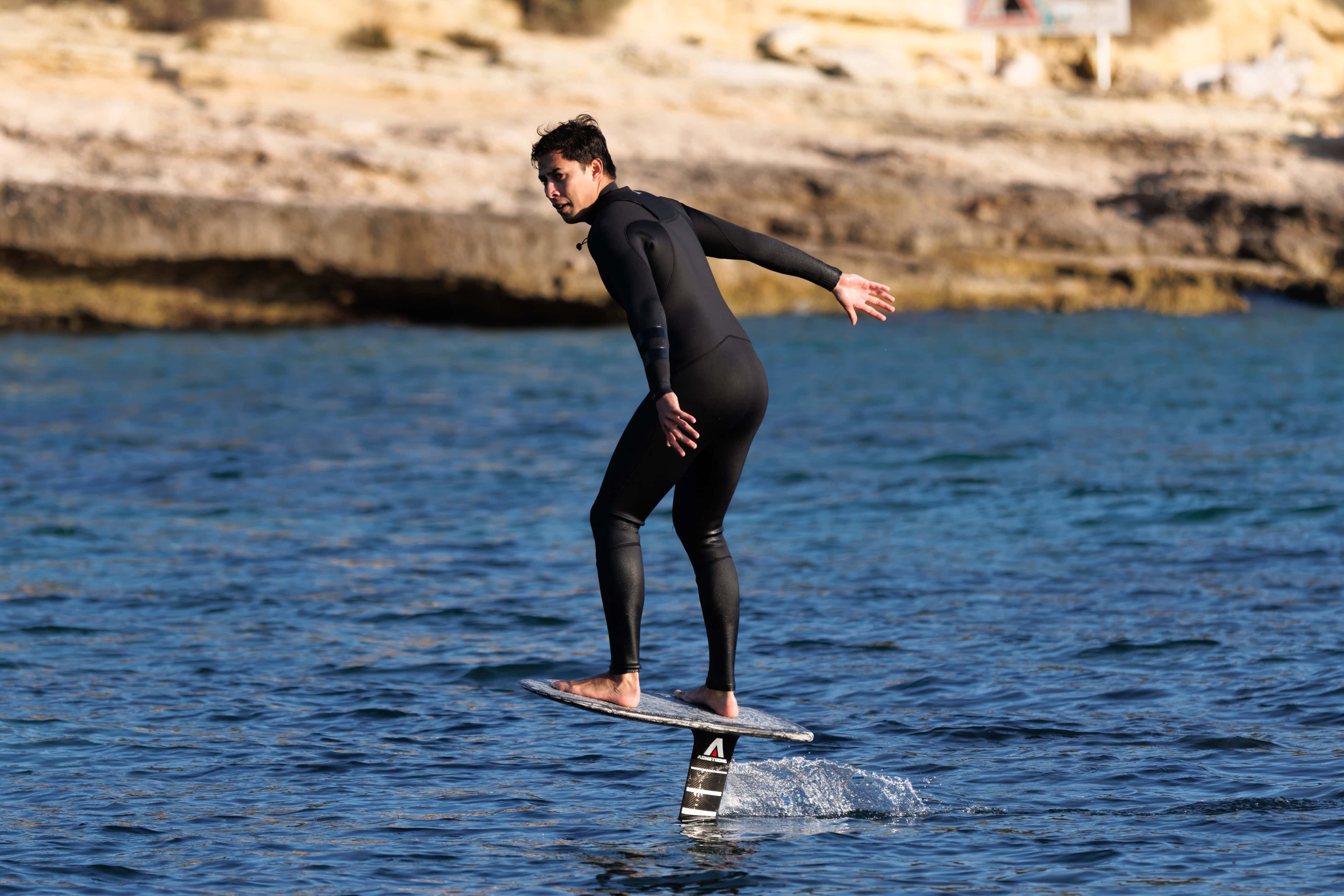 Surfeur en foil sur l'eau, pratique de surf avec foil, technique moderne.