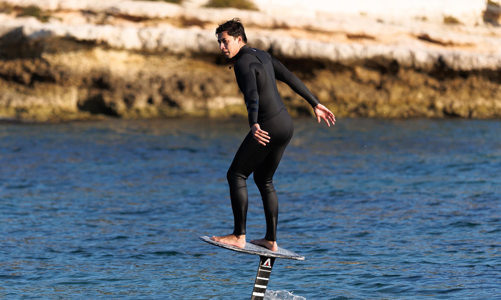Voleur de surf foil en action sur l'eau, pratique dans un environnement naturel.