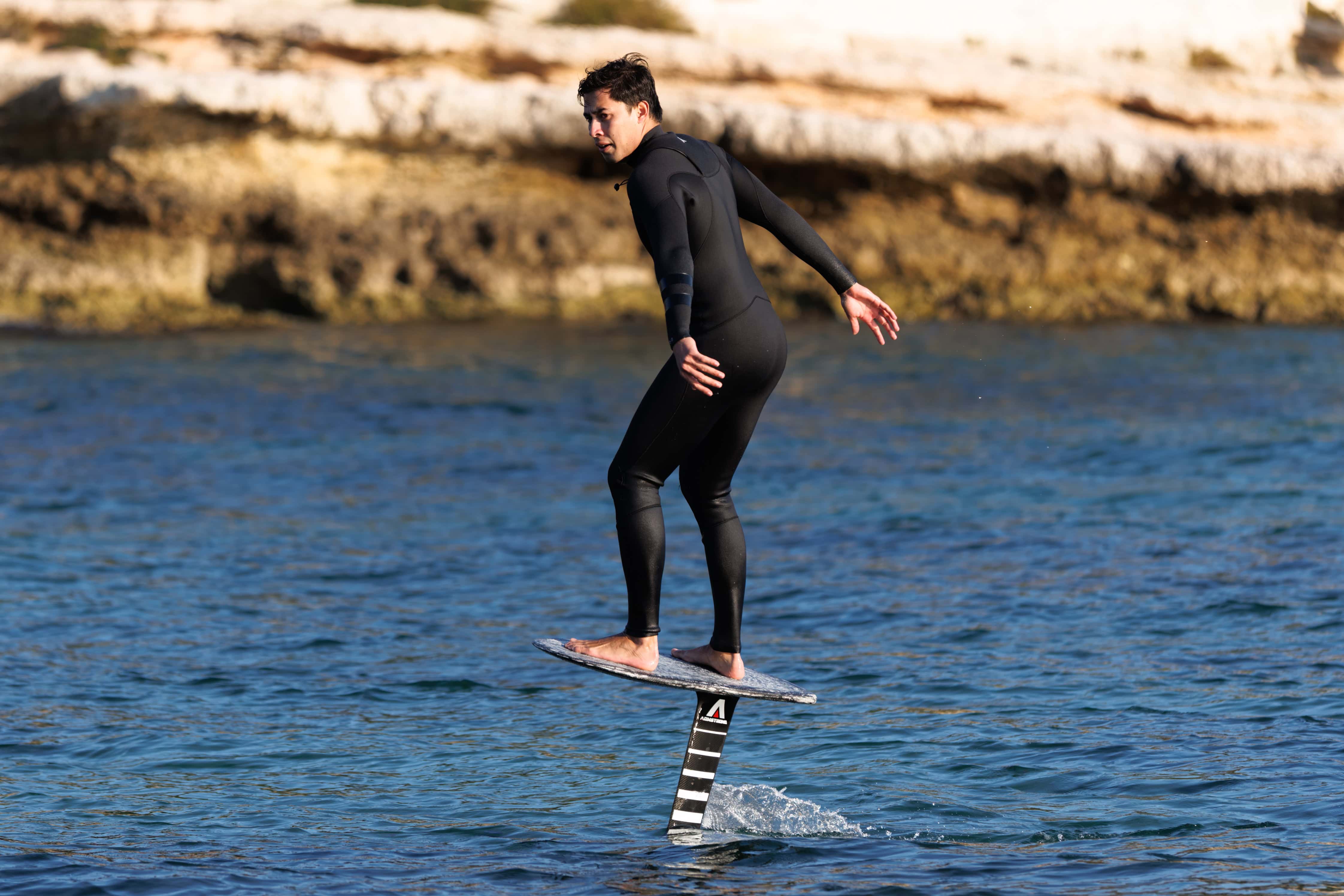 Voleur de surf foil en action sur l'eau, pratique dans un environnement naturel.